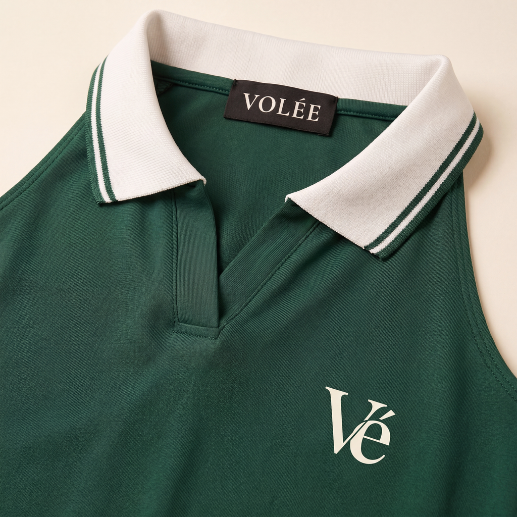 Close-up of The Court Dress in Forest collar, Volée neck label, and cream Vé chest monogram.