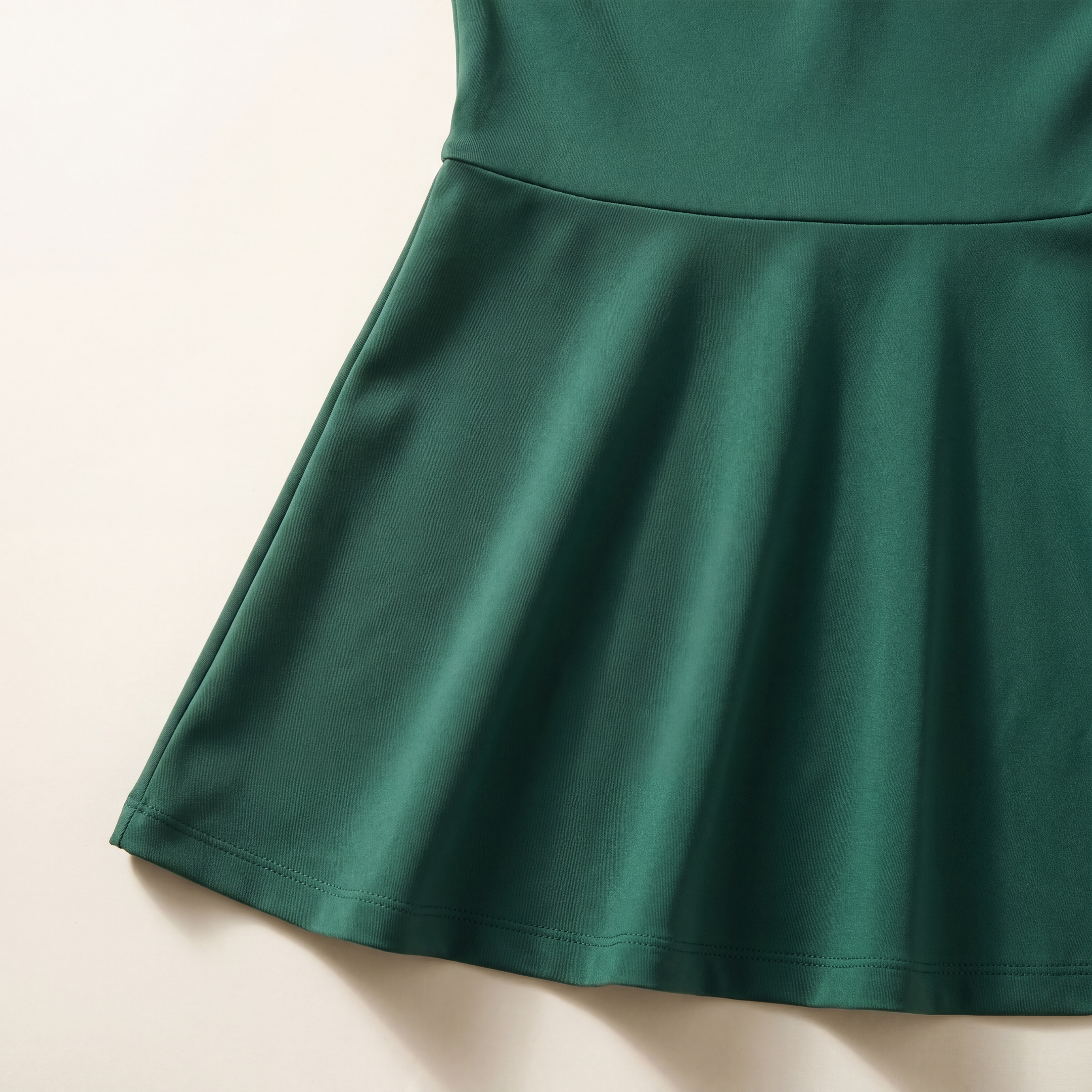 Close-up of The Court Dress in Forest skirt fabric, waist seam, hem stitching, and A-line drape.