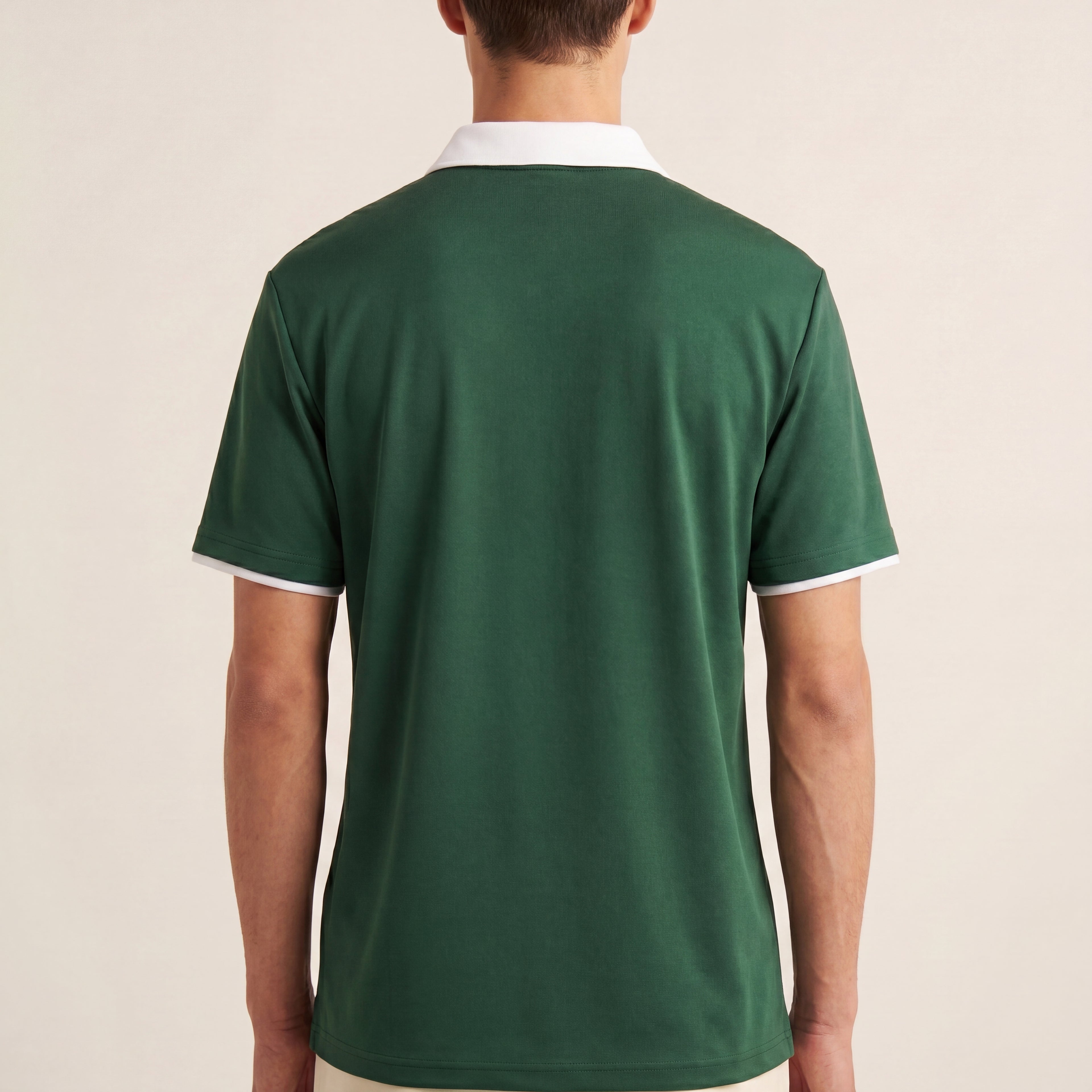 The Court Polo in Dark Green, back on-body view showing the white contrast collar, sleeve trim, relaxed drape, and blank back.