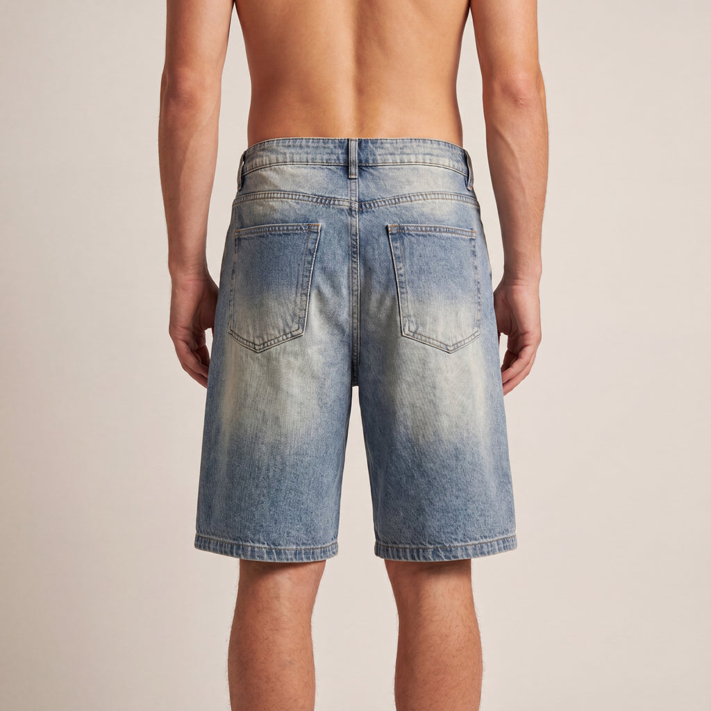 The Faded Denim Short in Blue, back on-body view showing the baggy knee-length cut, back pockets, and faded wash.