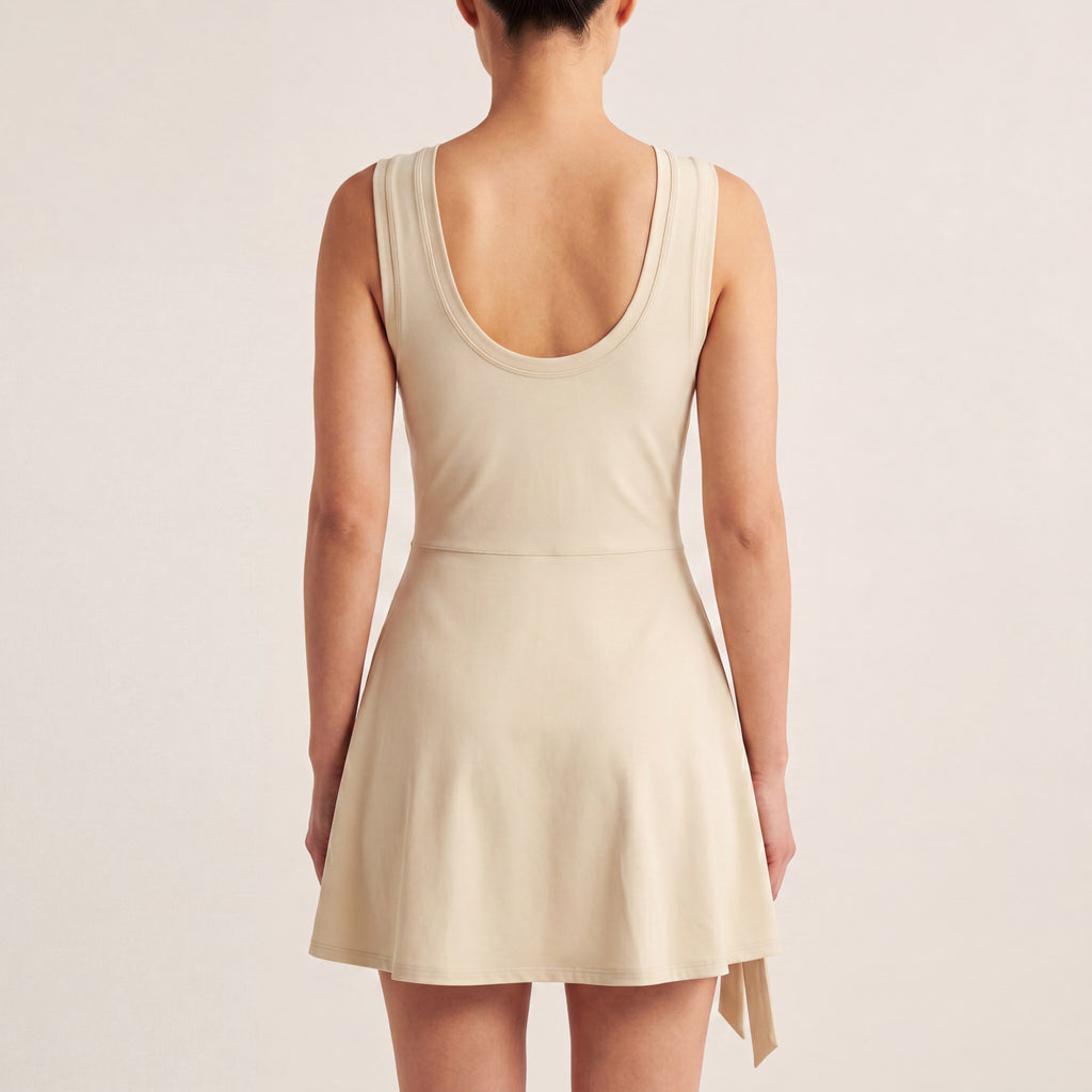 The Garden Dress in Light Apricot, back on-body view showing the scoop back, sleeveless bodice, and A-line skirt.