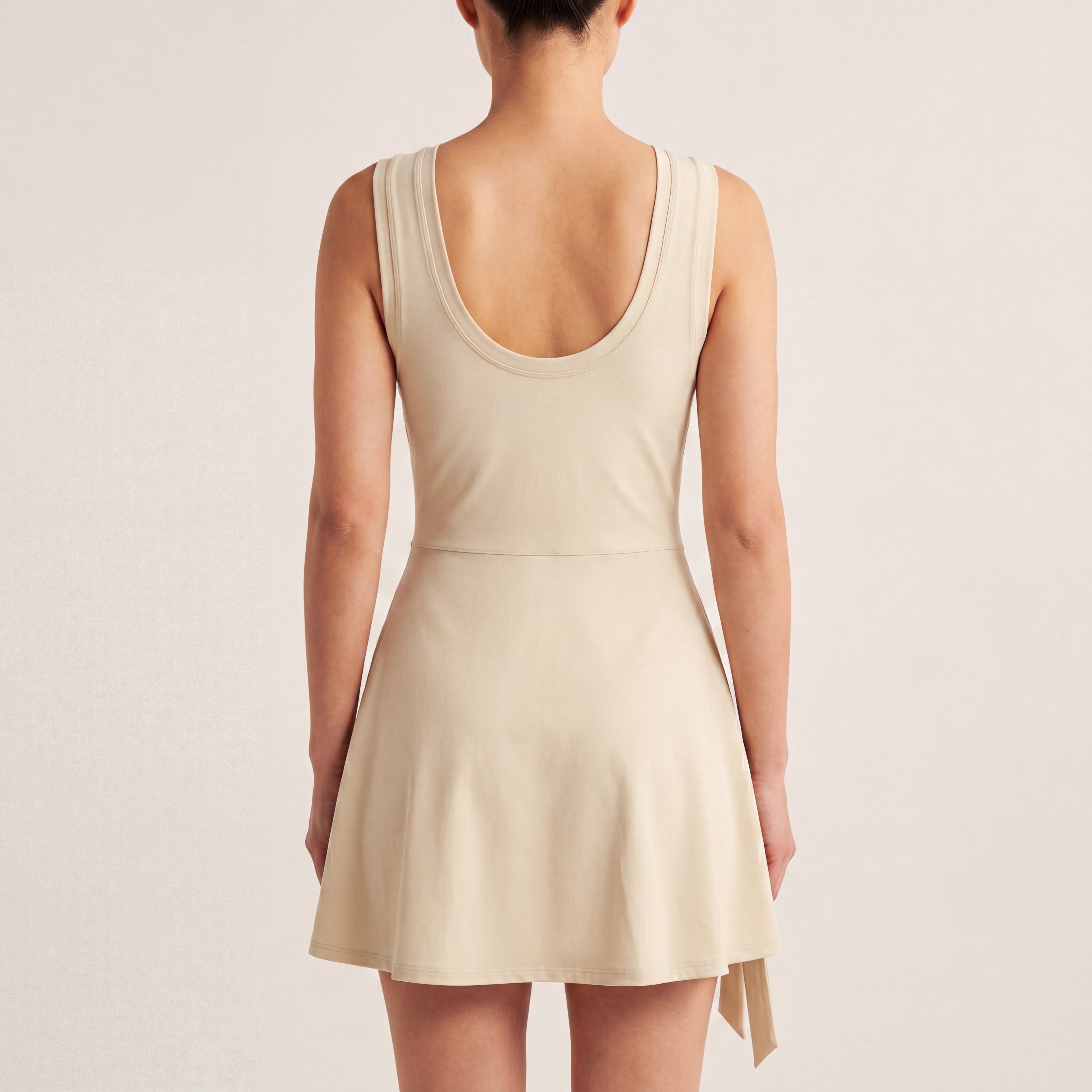 The Garden Dress in Light Apricot, back on-body view showing the scoop back, sleeveless bodice, and A-line skirt.