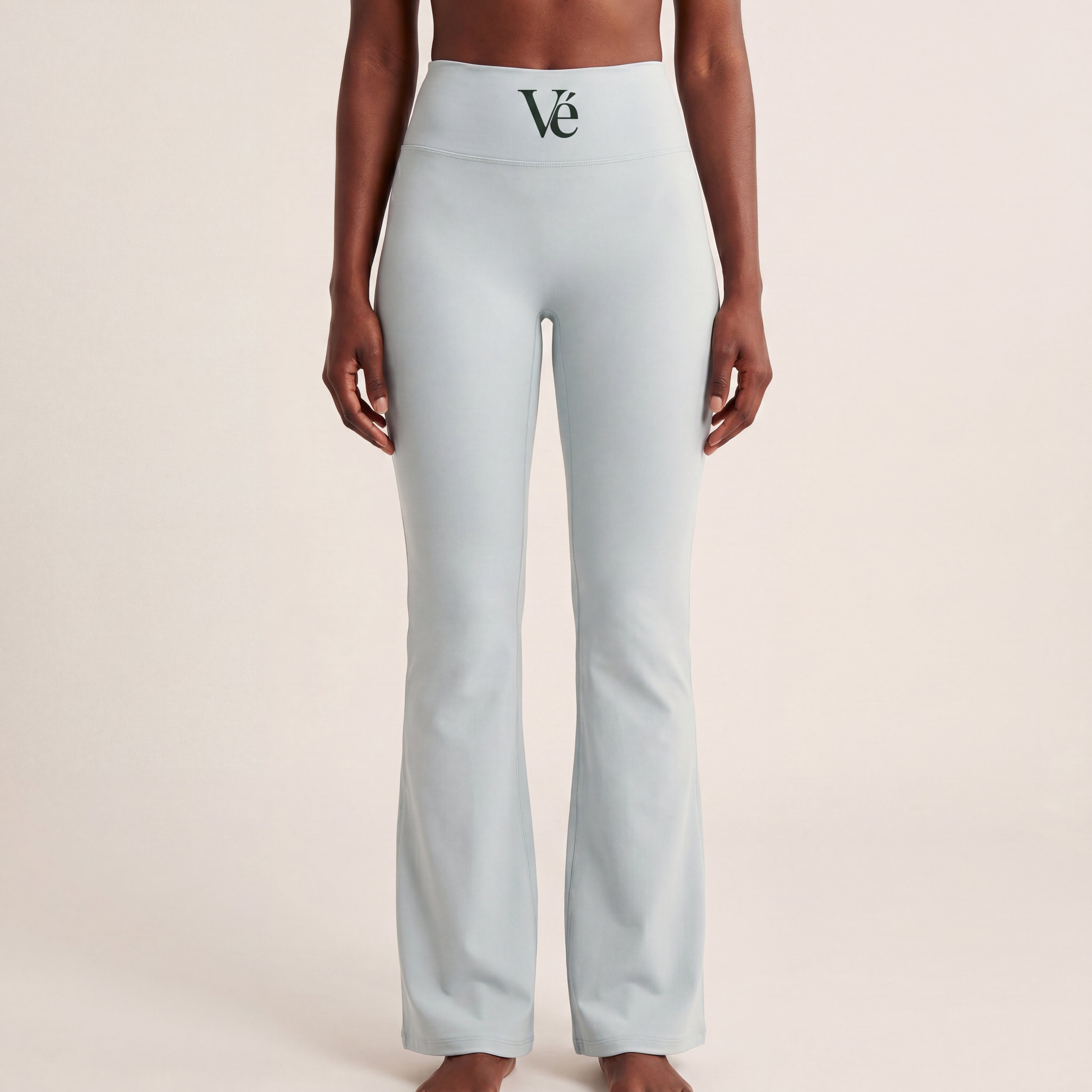 The Flare Legging in Gray, front on-body view showing the high-rise waistband, dark green Vé mark, and flared leg.